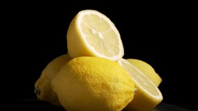 Lemons whole and cut. Fresh yellow lemons, whole and halved, rotate under studio lighting on a black background. The glossy texture and citrus details evoke freshness. - Powered by Shutterstock - Get 15% off with code: PIKWIZARD15