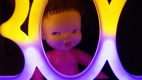 Creepy doll head sits against dark background, illuminated by shifting Halloween lights. Eerie glow highlights doll unsettling expression, enhancing spooky atmosphere. Boo inscription. - Powered by Shutterstock - Get 15% off with code: PIKWIZARD15