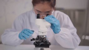 Dedicated adult researcher examines samples with microscope in a high tech lab. Documenting findings advances medical understanding. - Powered by Shutterstock - Get 15% off with code: PIKWIZARD15