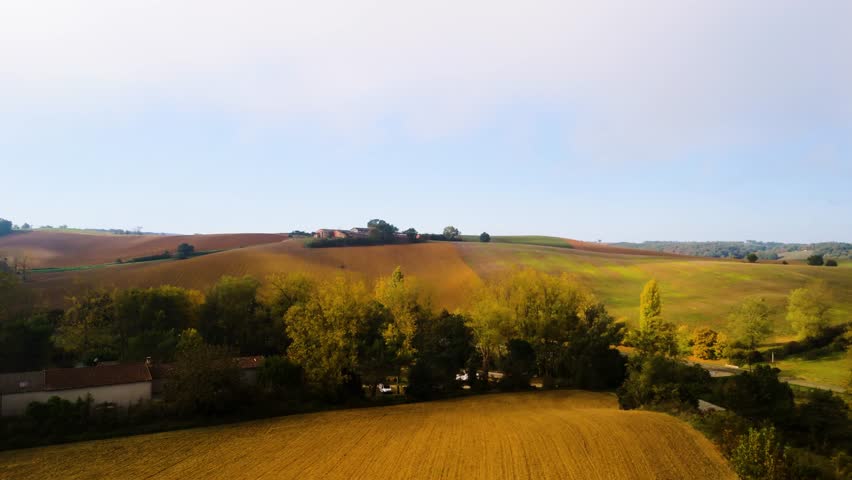 Sunlit Autumn Farmland Emerging Through Low Fog Beneath Cloud-Streaked Sky