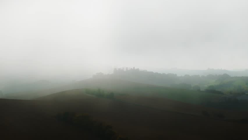 Drone Pass Through Thick Mist Over Hills — Soft Autumn Illumination in the Fog