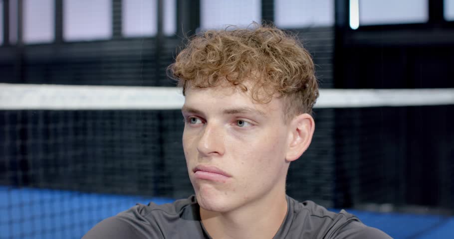 male athlete sitting in sports hall scanning court net for serve while digital glitch breaking feed. Sports, sporty, gym, fitness, concentration, technology, digital