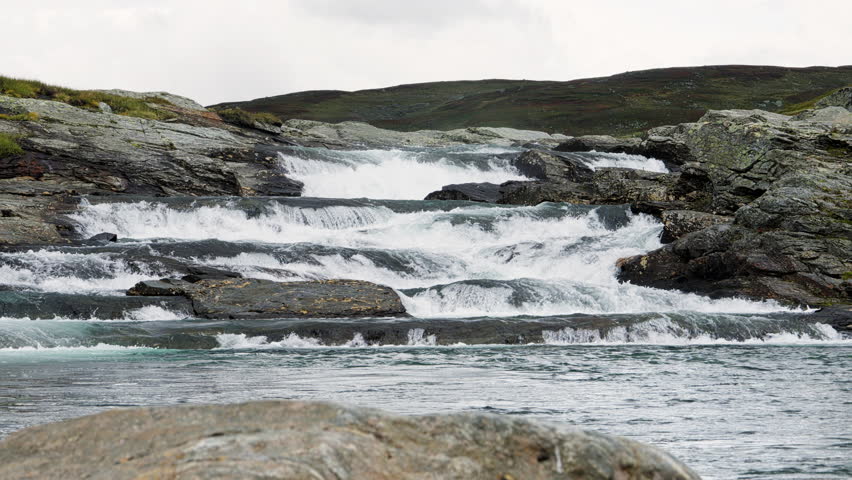 Rapid river water flowing over rocky cascades in the Scandinavian mountain wilderness of Stekenjokk, Sweden, a powerful and pristine natural landscape along the Wilderness Road