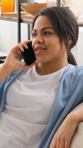 Young woman having a conversation on her phone at home.