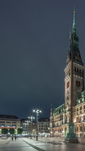 Building of the Hamburg City Hall night timelapse hyperlapse, the seat of government of Hamburg, located in the Altstadt quarter in the city center. Front view from the main square under a cloudy sky