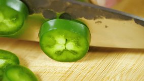 Chef Hand Cutting Green Jalapeno Pepper with Sharp Knife onto Cutting Board into Pile of Slices in Slow Motion - Powered by Shutterstock - Get 15% off with code: PIKWIZARD15