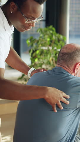 Therapist, senior man and physiotherapy for back pain, spine assessment and healing. Physiotherapist, helping and elderly person for mobility recovery, posture improvement and rehabilitation wellness