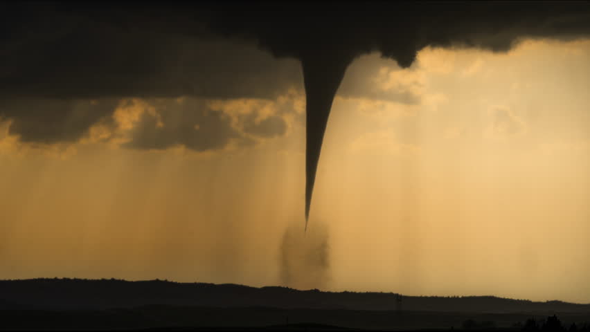 A dark tornado spins violently beneath black storm clouds and heavy rain, showcasing the raw intensity, motion, and destructive power of severe weather in dramatic detail
