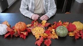 Man Eating Candy Corn for Halloween in Fall at Festive Dinner Table in Dark Wood - Powered by Shutterstock - Get 15% off with code: PIKWIZARD15
