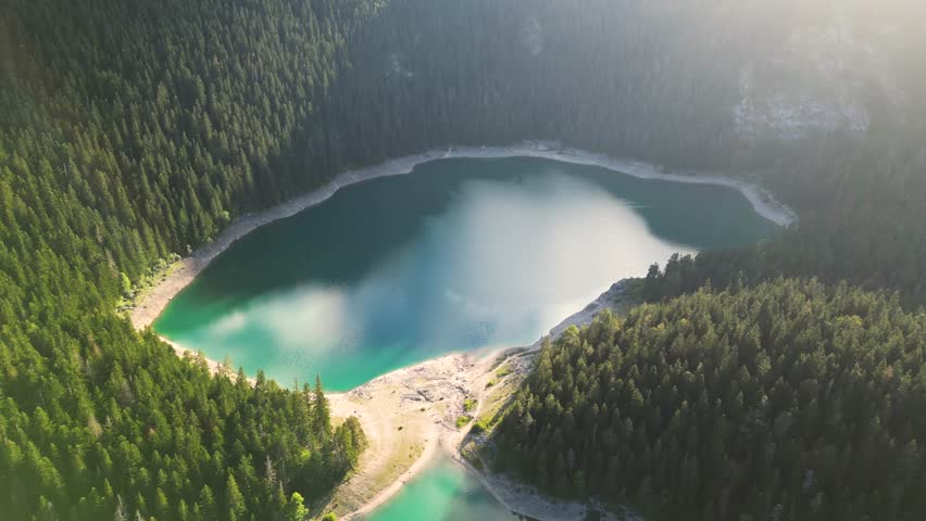 Aerial view of the beautiful Crno lake in Durmitor national park with clouds reflecting in the water