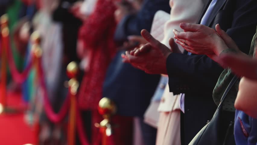 Actors, celebrities and stars on red carpet, guests and fans cheer an clapping hands, welcome, applause and ovation on cinema movie premiere, film festival award ceremony, ropes and golden barriers