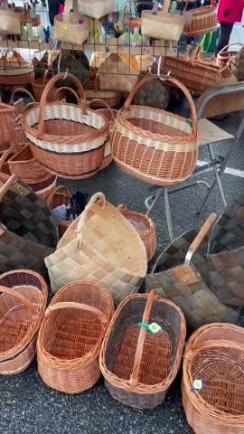Vertical screen handmade wicker baskets displayed at outdoor fair market traditional craftsmanship natural materials rustic atmosphere autumn sunlight and local culture