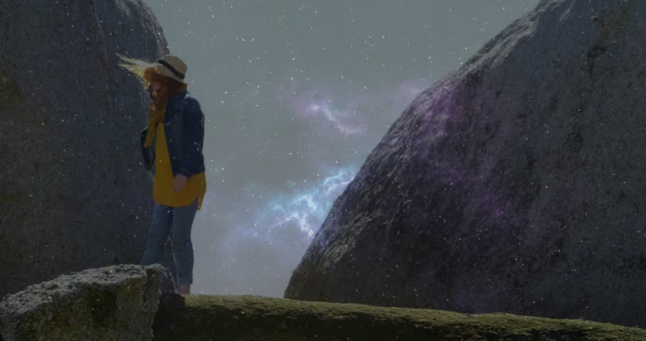 Woman stepping along ledge after gazing ahead, technology adding star field lens flare. Adventure, exploration, cosmic, wilderness, nature, movement, serenity