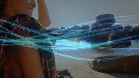 Woman adjusting hair and turning while admiring sunlit sea with animated teal-blue streaks for tech. Beach, dunes, ocean, sunset, silhouette, abstract, tranquility - Powered by Shutterstock - Get 15% off with code: PIKWIZARD15