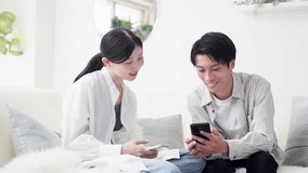 Smiling Asian couple looking at a smartphone - Powered by Shutterstock - Get 15% off with code: PIKWIZARD15