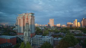 Cityscape of London at sunset with warm light reflecting off modern skyscrapers, a tall church spire in the foreground, and dramatic clouds over a mix of old and new architecture. - Powered by Shutterstock - Get 15% off with code: PIKWIZARD15