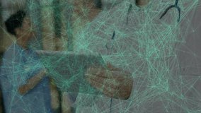 Male doctor responding to pulsing network overlay by tapping tablet and viewing records in lobby. Medical, technology, healthcare, digital, professional, modern, communication - Powered by Shutterstock - Get 15% off with code: PIKWIZARD15