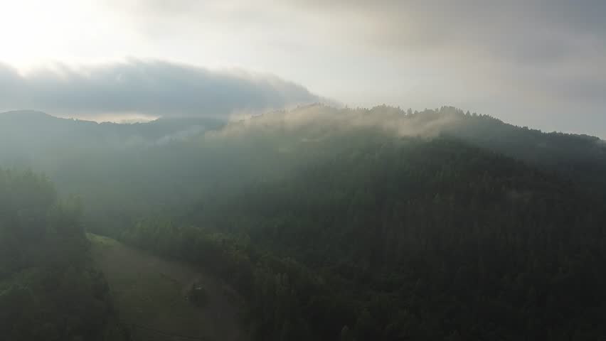 Golden hour sun shining on forest mountain village