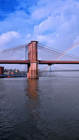 Brooklyn Bridge with rainbow over the East River, New York. A beautiful rainbow appears over the Brooklyn Bridge