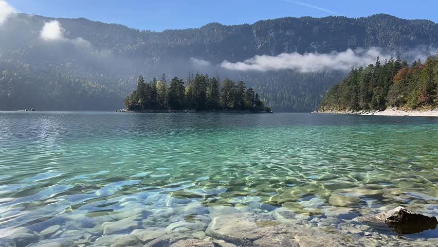 Timelapse of the picturesque island Sasseninsel at popular lake Eibsee near Garmisch-Partenkirchen in the Bavaria region of Germany on a sunny autumn day