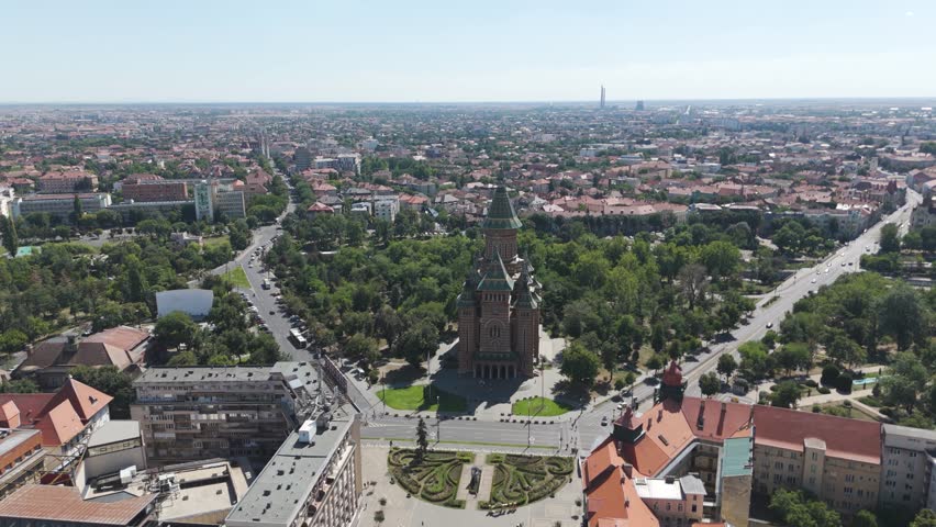 Aerial drone footage approaching the Metropolitan Cathedral in Timisoara, Romania, highlighting its architecture and surrounding cityscape.