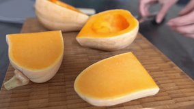 A woman's hand cuts a fresh pumpkin into pieces with a knife. Close-up. - Powered by Shutterstock - Get 15% off with code: PIKWIZARD15
