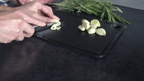 A woman chops garlic on a cutting board. Modern kitchen. - Powered by Shutterstock - Get 15% off with code: PIKWIZARD15