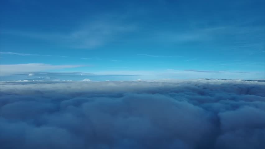 An immersive pilot’s perspective from a jet cockpit flying over and into an endless blanket of stratus clouds at sunset.