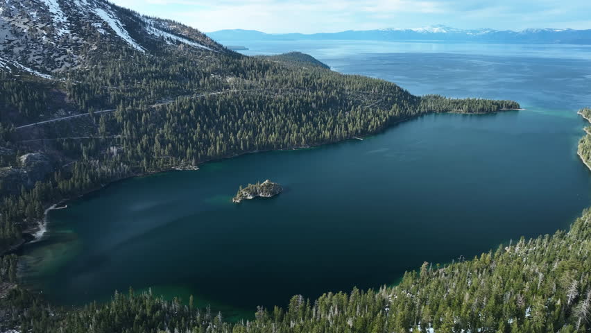 Panoramic drone shot of the snowy Emerald bay, spring day at Lake Tahoe, USA
