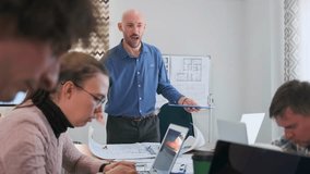 Architectural team under pressure as their bald boss shouts about a blueprint error. Employees quietly keep working, focused on correcting the mistake. Workplace tension, authority, and stress. - Powered by Shutterstock - Get 15% off with code: PIKWIZARD15