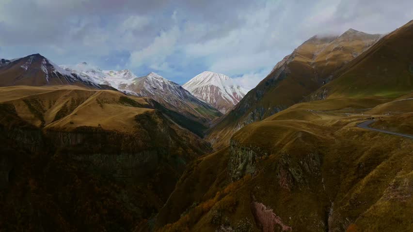 Epic drone footage of the Friendship Monument on Georgian Military Road with breathtaking Caucasus mountains in the background.