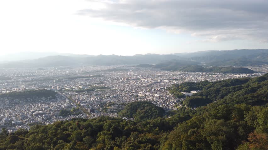 Aerial panoramic view of Kyoto City Japan, town around green mountain Valley