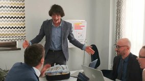 Manager in suit opens suitcase of cash and distributes dollar bills as bribes during office meeting, illustrating corruption, fraud, and illegal money exchange.  - Powered by Shutterstock - Get 15% off with code: PIKWIZARD15