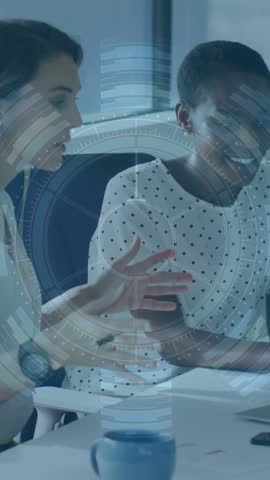 Animation of graphs and trading board, multiracial colleagues sharing ideas over laptop in office. Digital composite, multiple exposure, teamwork, finance, stock market, investment and technology.