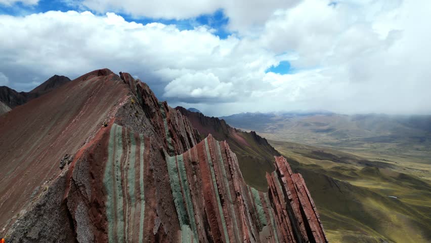Aerial 4K footage of Peru’s southern Rainbow Mountains near Palccoyo. Sharp ridges and layered mineral colours cut across the high Andes under crisp mountain light.