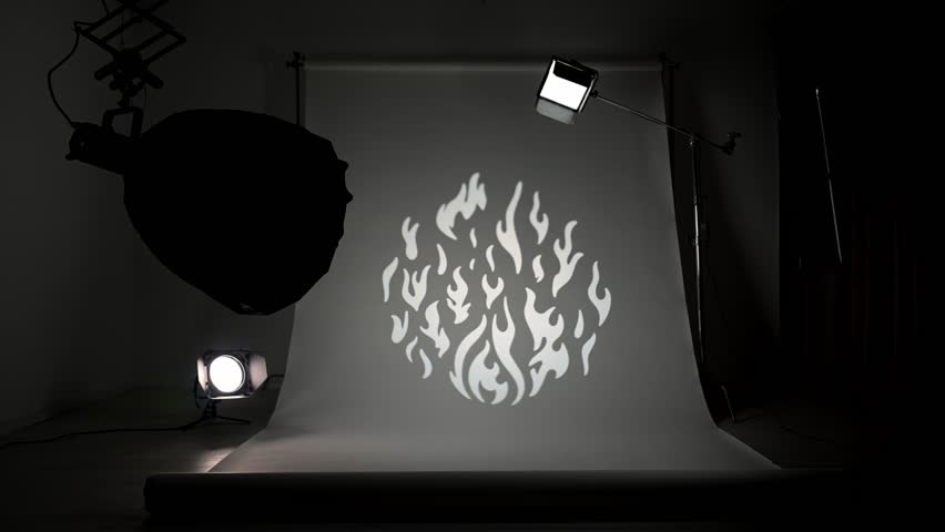 Interior of a professional studio. Professional studio for photo and video production filming with modern lighting equipment, white cyclorama background, testing color spotlight fire pattern filter.