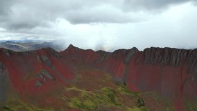 Drone footage capturing moody Andean weather over the red mountains of southern Peru. Rain sweeps across the ridges as sunlight breaks through storm clouds. - Powered by Shutterstock - Get 15% off with code: PIKWIZARD15