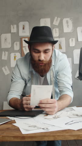 male fashion designer analyzing sketches in atelier symbol of mindful creativity slow work sustainable brand building vertical slow motion fullhd stock video