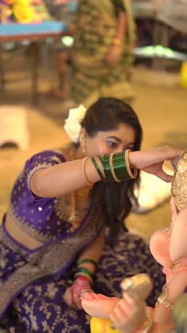 Indian Woman in Traditional Saree Holding Lord Ganesha Idol During Ganesh Chaturthi Celebration