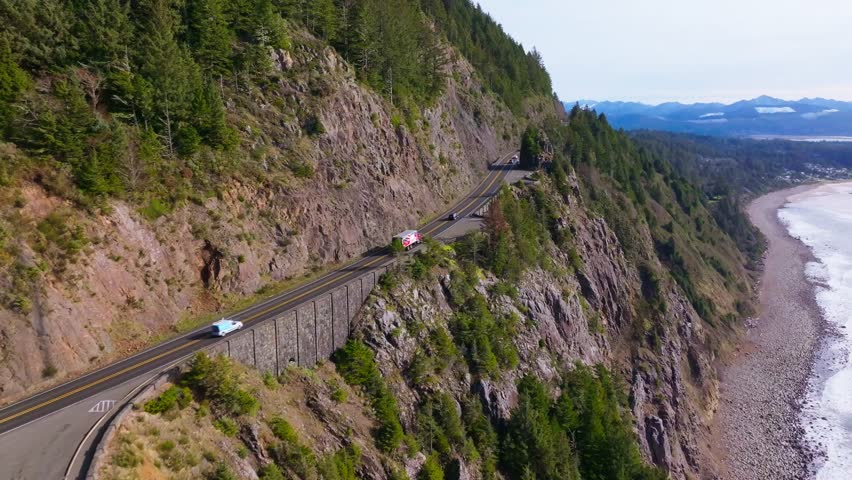 Aerial Drone View of Oregon Coast Highway 101 With Cars Winding Along Ocean Cliffs