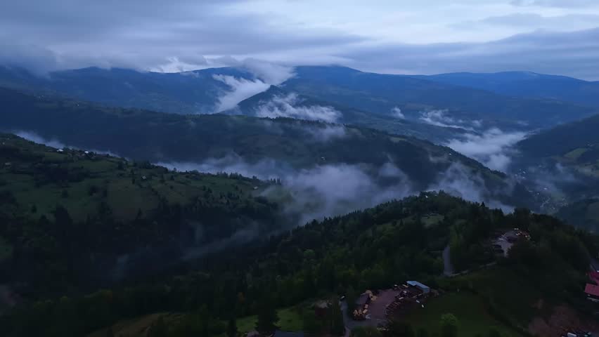 Dramatic aerial hyperlapse over the Apuseni Mountains near Mătișești with swirling evening mist around the valleys in Romania.