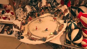 Decorative miniature winter skating scene with figurines, snow, lights and trees arranged in festive Christmas shop display - Powered by Shutterstock - Get 15% off with code: PIKWIZARD15