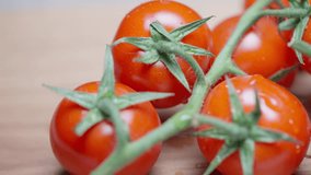 Slow motion close-up panning shot of fresh cherry tomatoes with green stems covered in water droplets. - Powered by Shutterstock - Get 15% off with code: PIKWIZARD15
