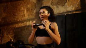 Motivated Black woman holding dumbbell and doing squats during workout in gym - Powered by Shutterstock - Get 15% off with code: PIKWIZARD15
