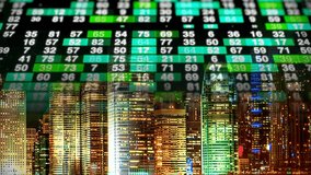 Red-colored stock exchange trading ticker merges into a brightly lit cityscape at night, illustrating finance, business activity, and market dynamics. - Powered by Shutterstock - Get 15% off with code: PIKWIZARD15