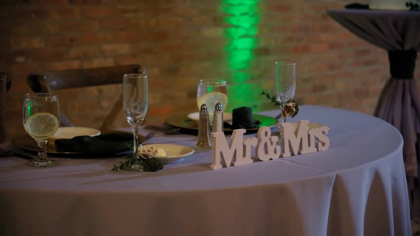 Elegant wedding venue banquet table setup with fine tableware, silverware, candles, and floral decorations arranged beautifully for a formal dinner celebration.