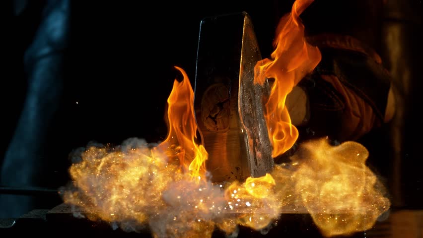 Close-up of blacksmith forging glowing hot iron on anvil with flying sparks. Super slow motion filmed on high-speed cinema camera at 1000 fps