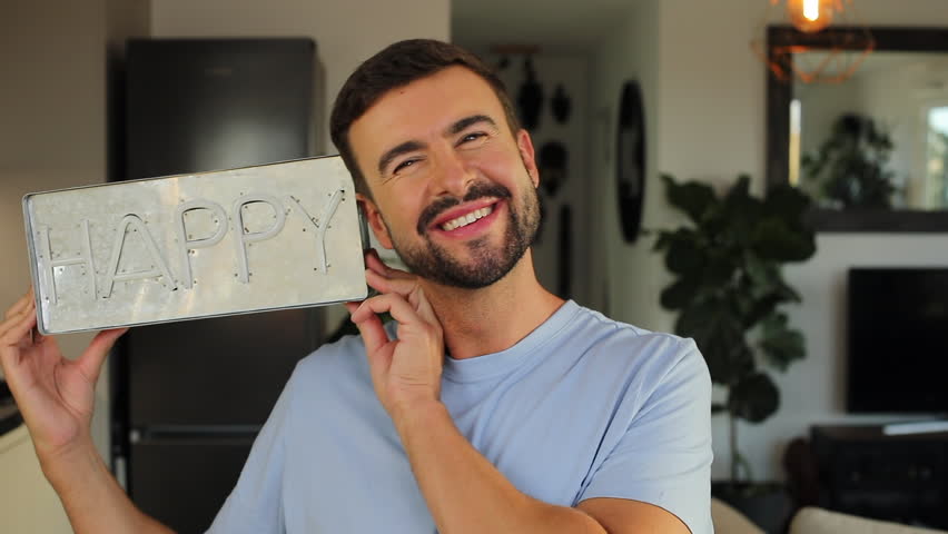 Cheerful man holding a "HAPPY" sign 