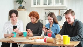 Home party. Friends holding smartphones touch screen typing scroll page in kitchen at home. People with cell phones surfing internet using social media apps on party. Internet news cellphone addiction - Powered by Shutterstock - Get 15% off with code: PIKWIZARD15