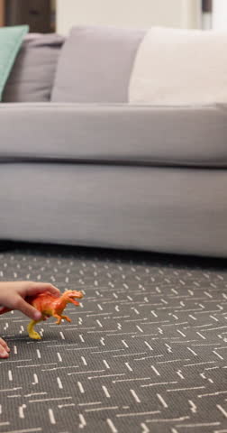 Children, hands and playing with dinosaur toys for playful childhood, imagination or bonding. Closeup, kids or siblings with animal raptors for fossil game, attack or cognitive skill on floor in home